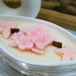 Bougie parfumée avec des fleurs et pot en jesmonite en forme de bateau